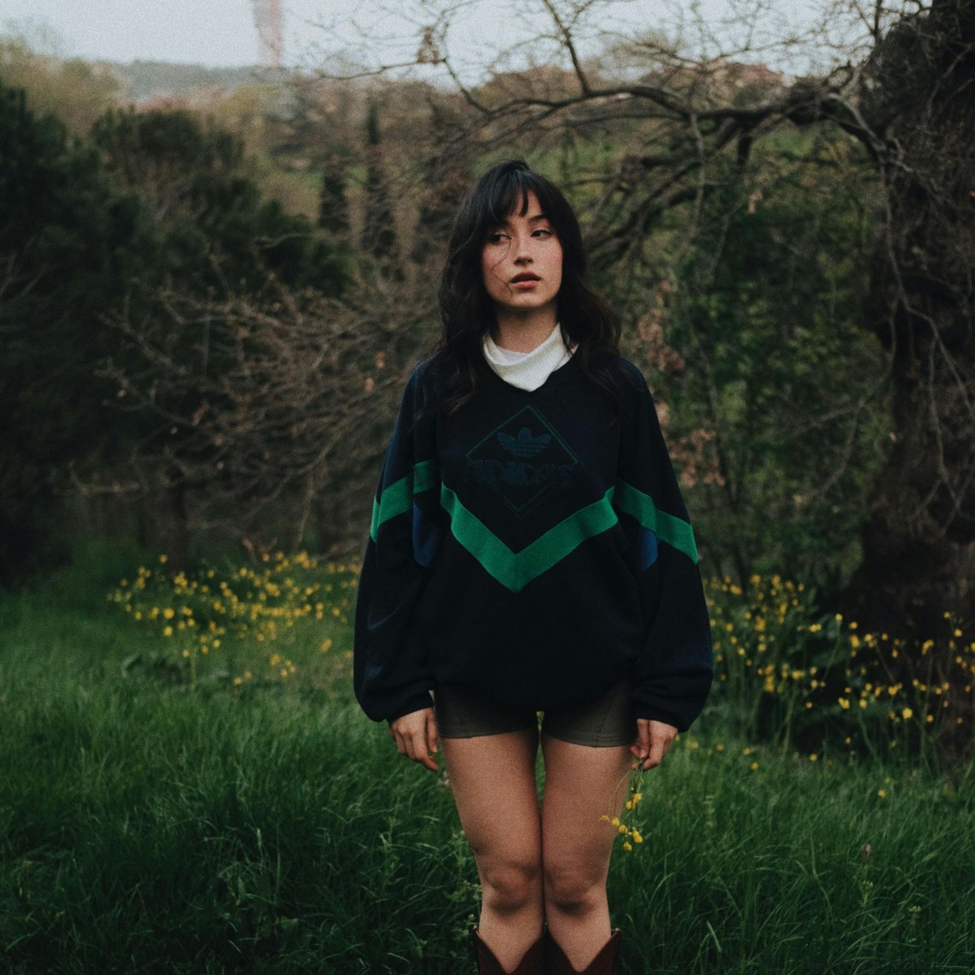 cô gái mặc áo sweater đen giữa vườn hoa