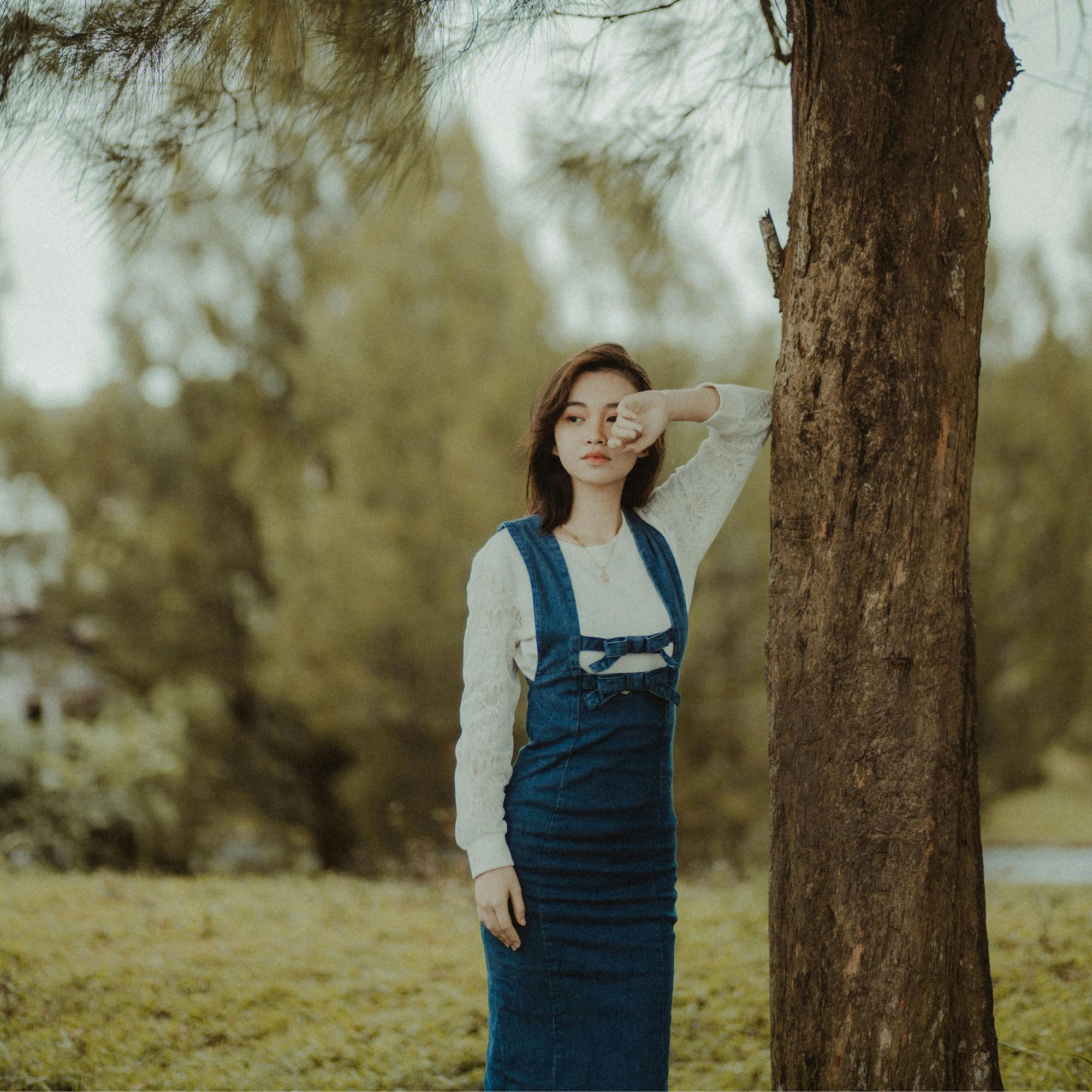 cô gái cung hoàng đạo tựa vào thân cây