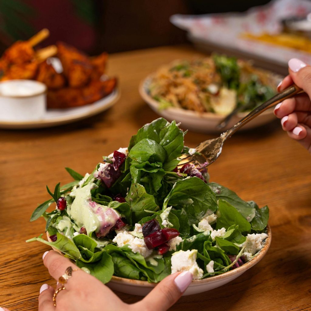 Tô salad tươi với nhiều loại rau xanh gồm cải xoăn, rau bina, cần tây được bày trí đẹp mắt trên bàn ăn.
