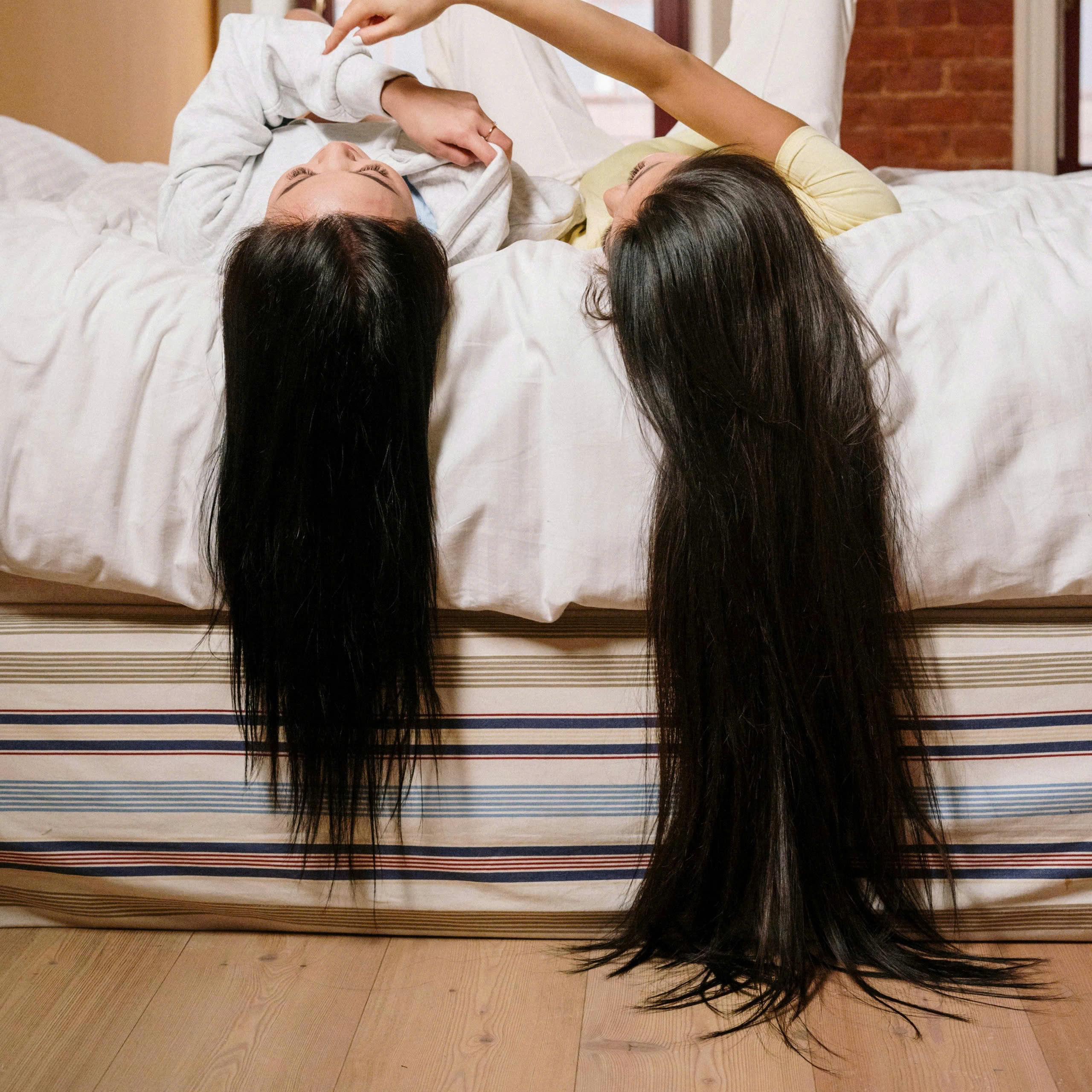 2 cô gái đang nằm xõa tóc - dưỡng tóc bằng dầu dừa