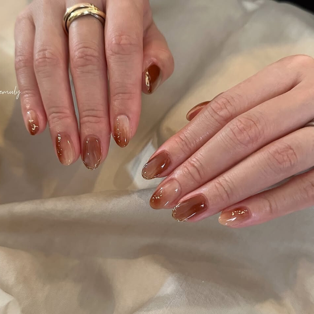 đôi tay với bộ nail nâu ombre