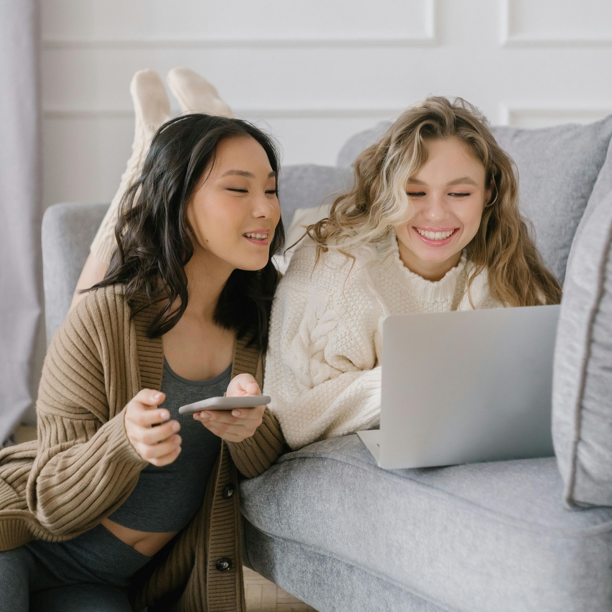 2 người bạn làm việc cùng nhau trên sofa