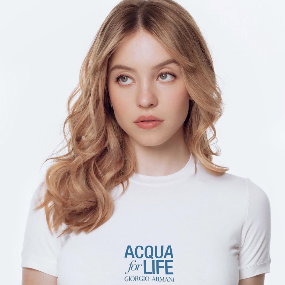 Sydney Sweeney uốn tóc xoăn sóng và trang điểm tone cam nude