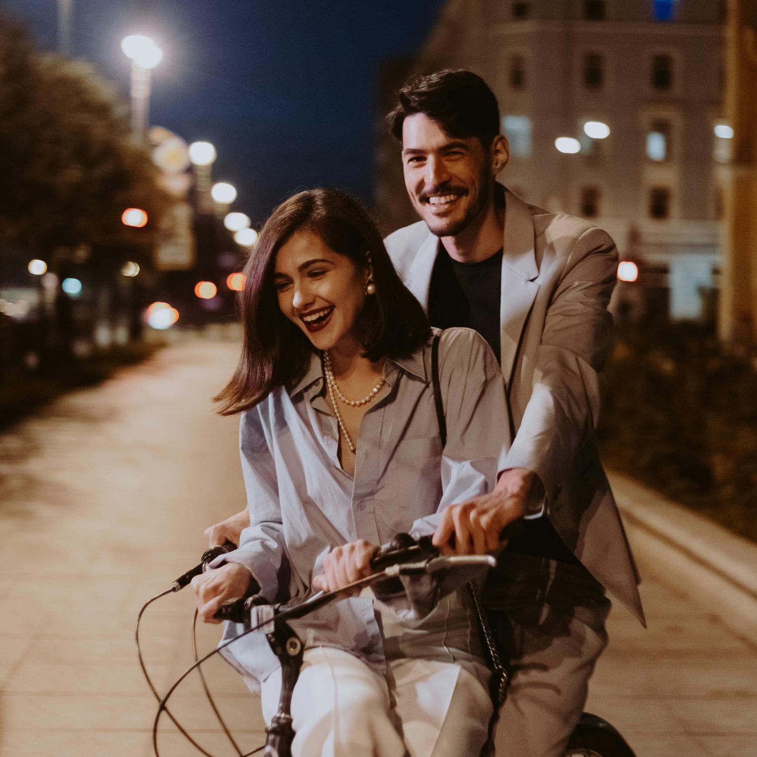Cặp đôi hẹn hò chạy xe đạp trên đường phố vào buổi tối