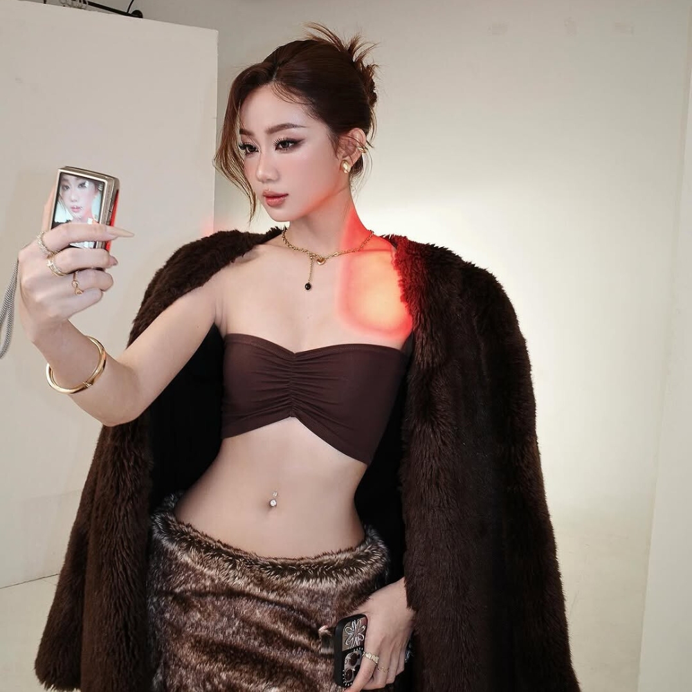 Cô gái mang trang phục nâu đang chụp ảnh.