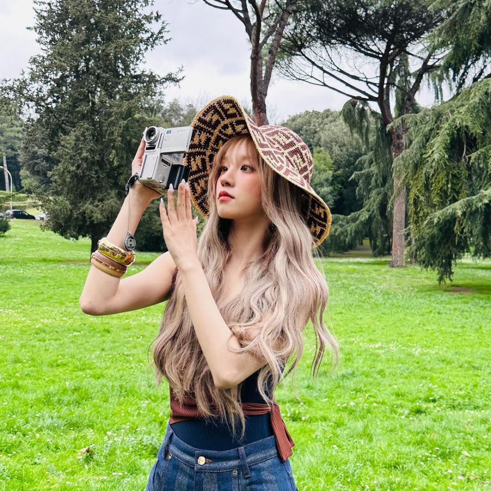 yuqi với mái tóc dài đang cầm máy ảnh