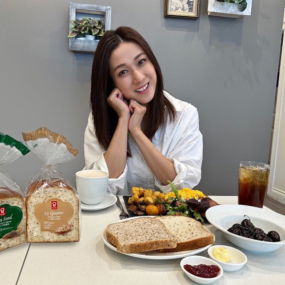 Chung Gia Hân chống tay lên cằm ngồi trước bàn ăn.