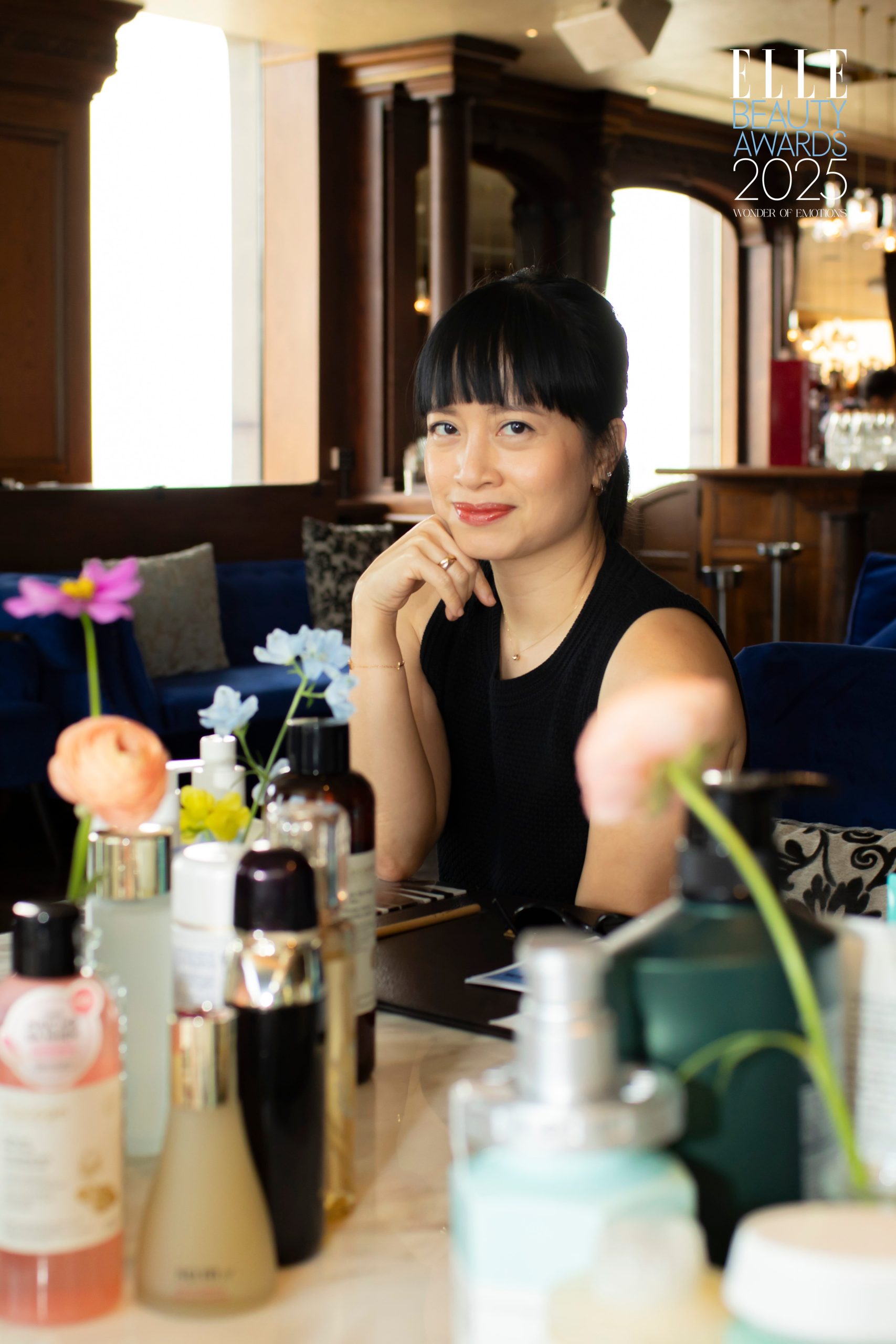 Director Editor Tạp chí ELLE Việt Nam Liên Chi Nguyễn ngồi tại bàn chấm điểm sản phẩm.