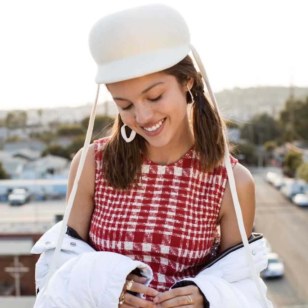 Hình ảnh Olivia Rodrigo đang mỉm cười với khuôn mặt lấm tấm tàn nhang.