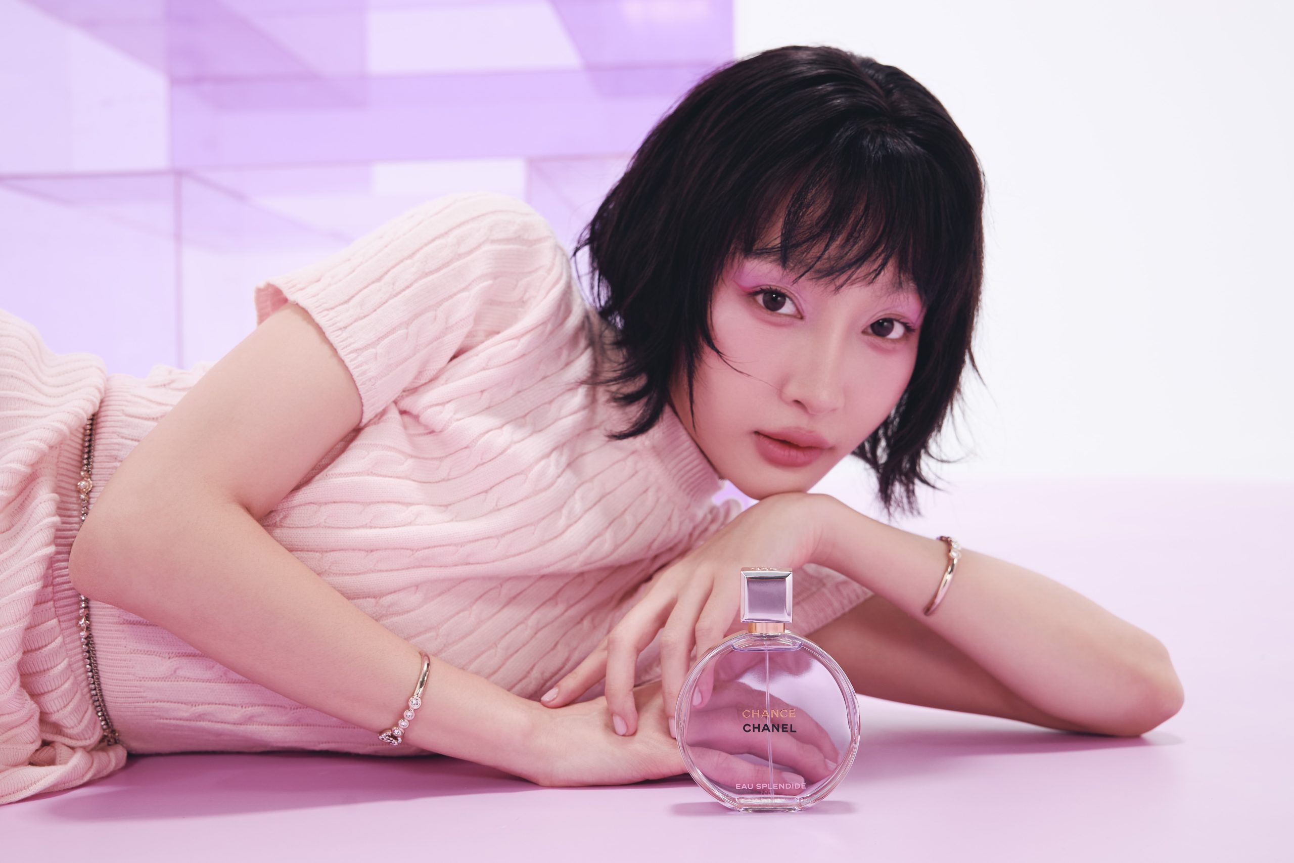 Juky San nằm nghiêng cầm lọ nước hoa Chanel Chance Eau Splendide