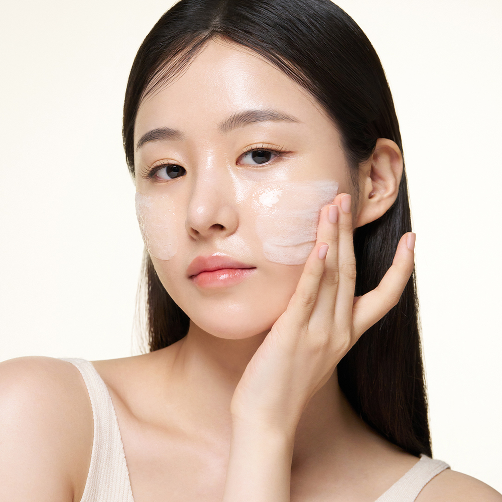Cô gái đang thoa tinh chất ốc sên lên mặt. 
