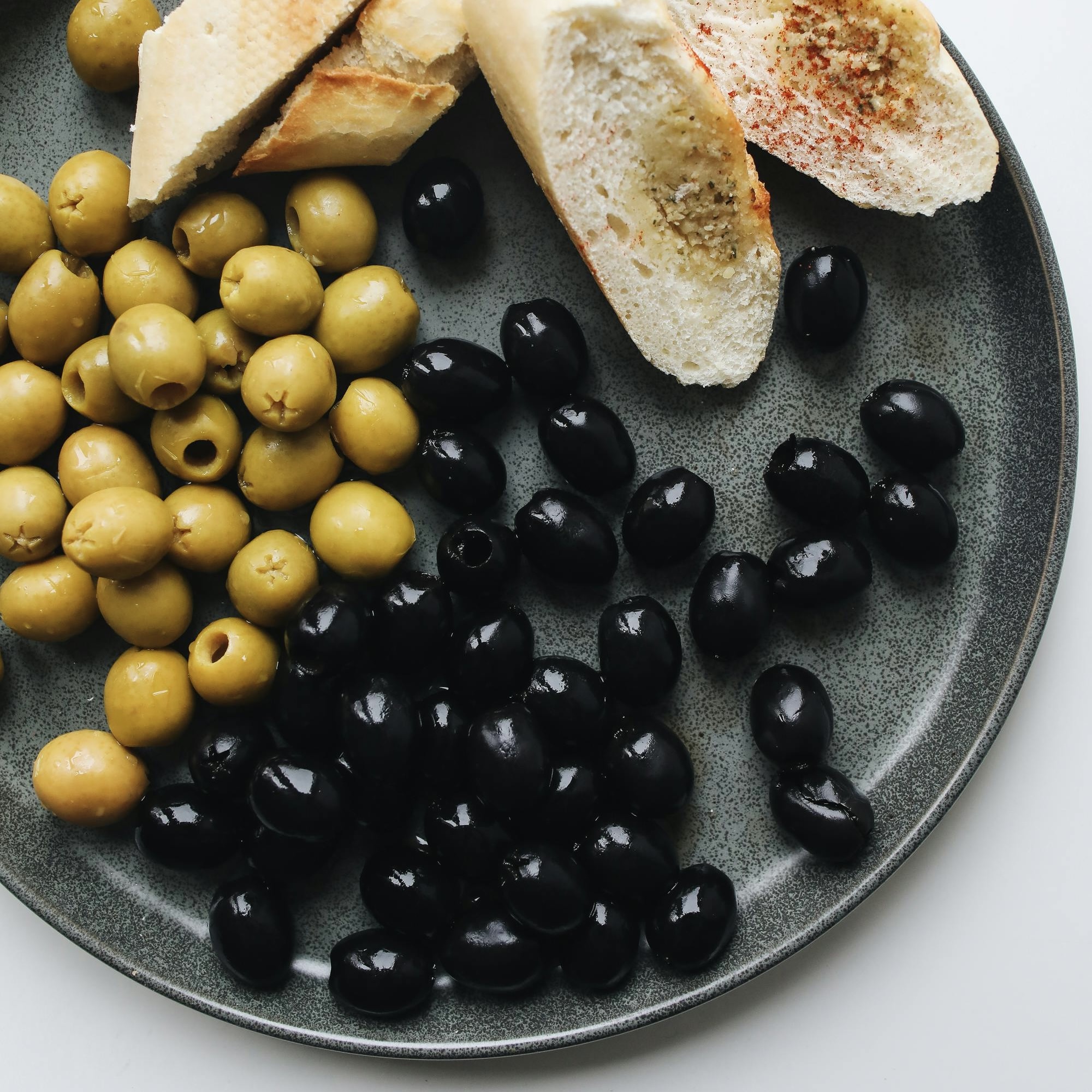  Đĩa đựng những quả olive tươi màu đen bóng.