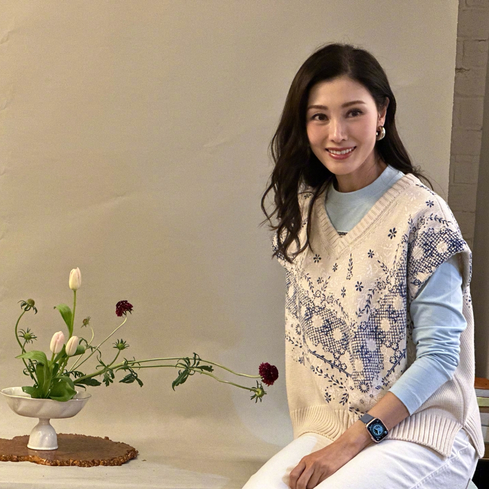 Lý Gia Hân ngồi bên cạnh chậu hoa