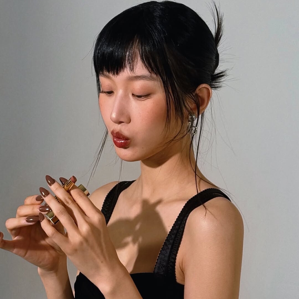 Cô gái cầm thỏi son nâu