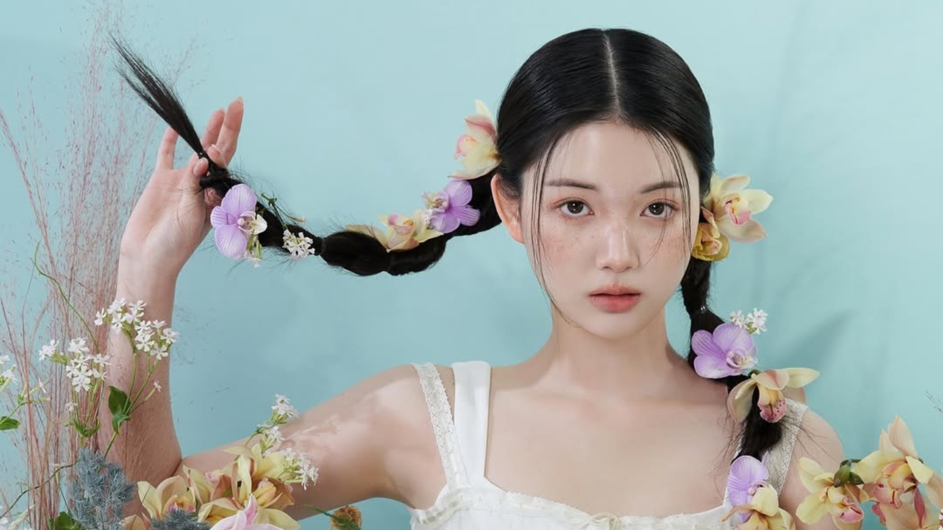 Cô gái tạo dáng với background hoa với điểm nhấn là má hồng