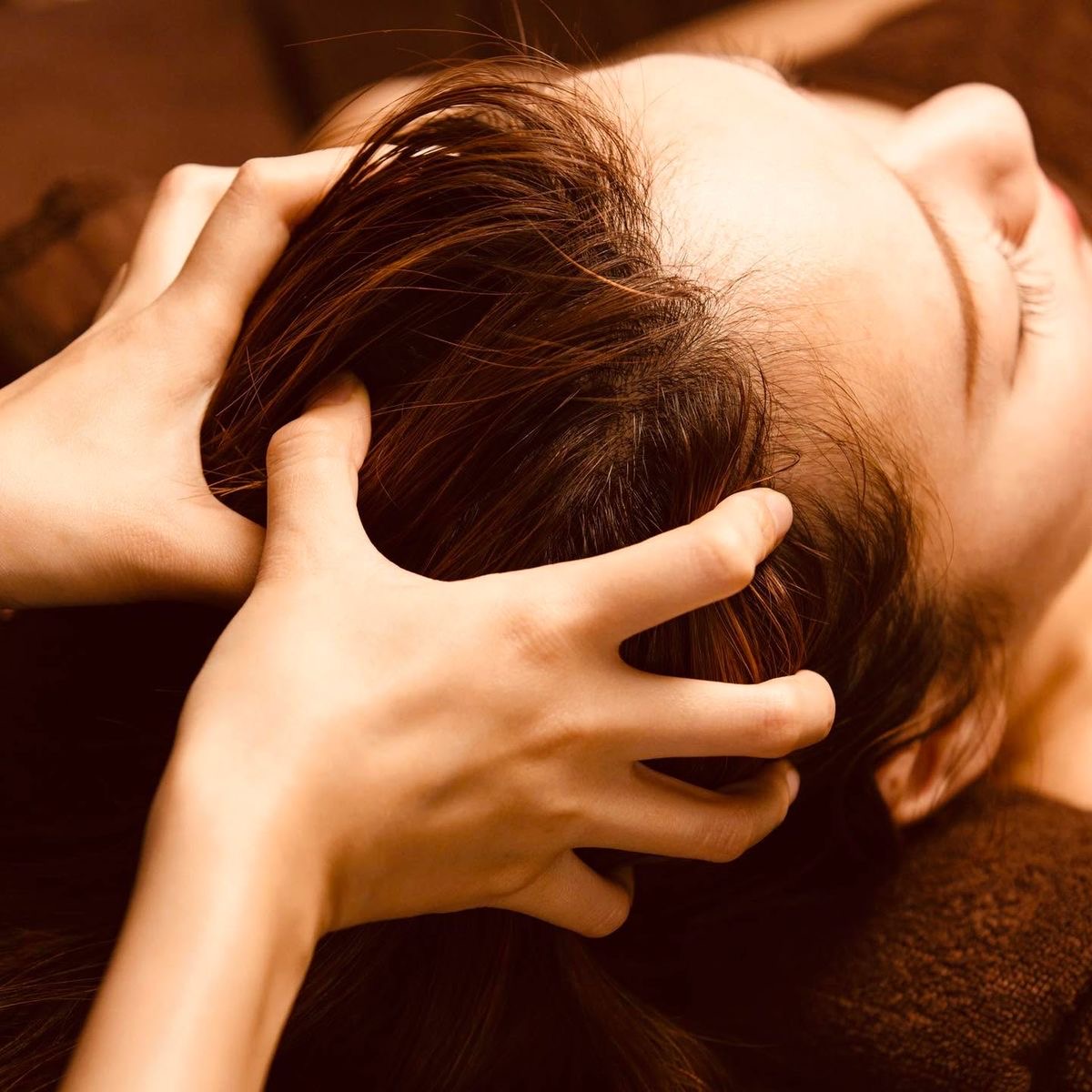 Người đang thực hiện massage da đầu nhẹ nhàng để kích thích tuần hoàn máu và hỗ trợ mọc tóc.