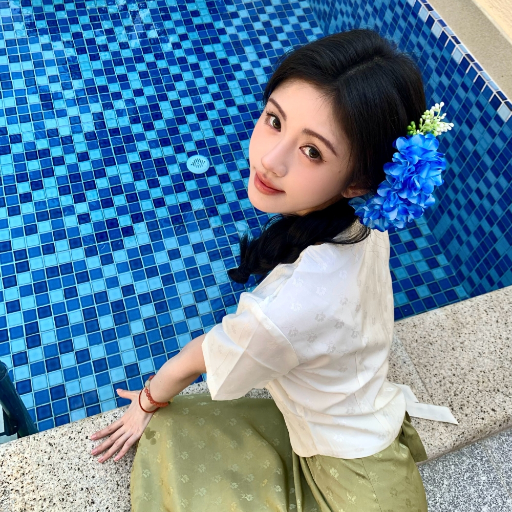 Cô gái tết tóc và cài hoa xanh trên tóc