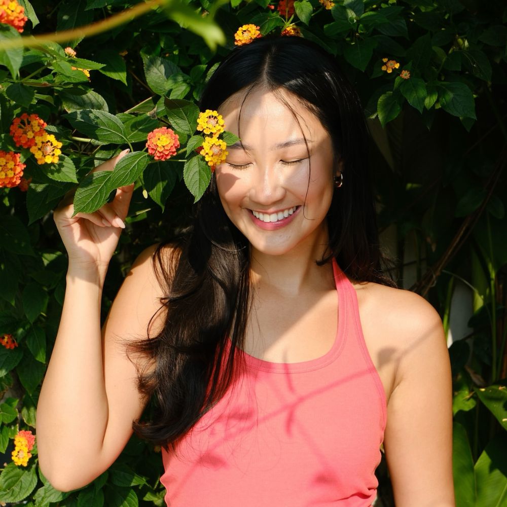 Hình ảnh Sabrina Uyên Lưu cười dưới tán cây và nắng.