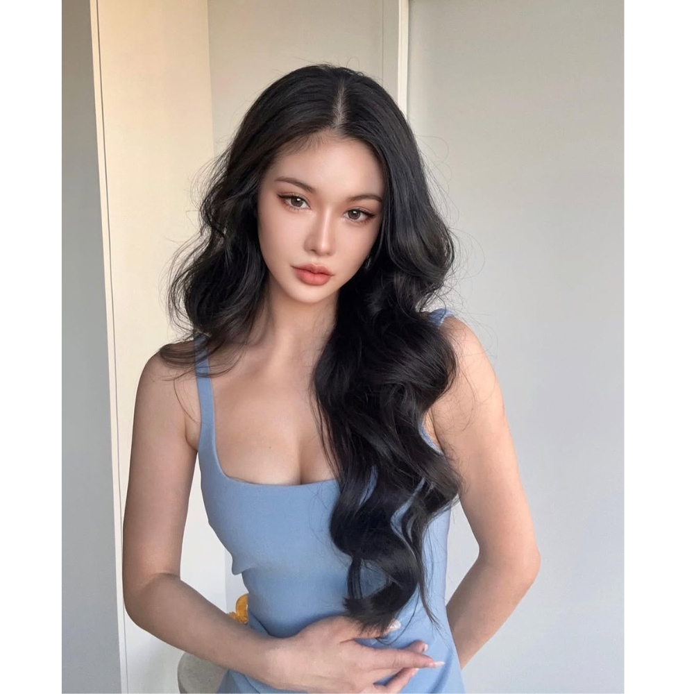 Cô gái tạo dáng trước ống kính với mái tóc uốn bồng bềnh.