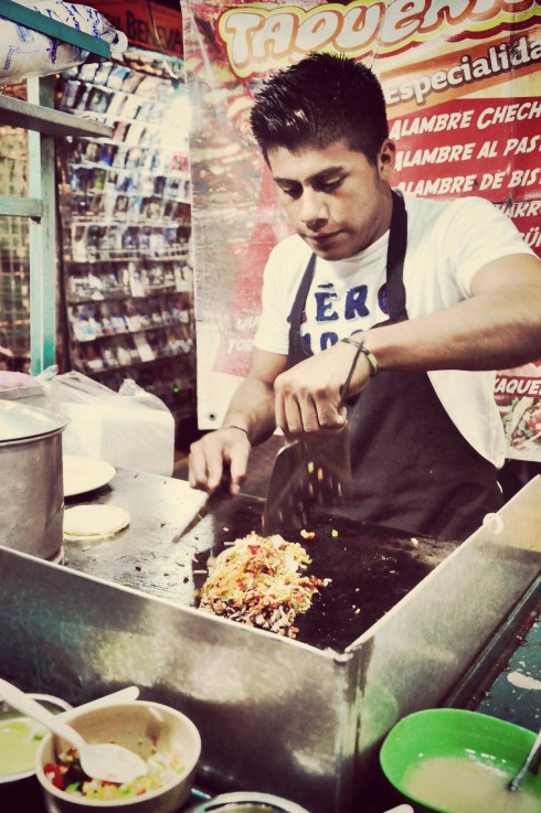 Bạn đầu bếp trẻ ở góc chợ thành phố Oaxaca đang làm nóng thịt Al Pastor.