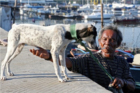 Lão ngư phủ đưa chú chó xuống thuyền ra biển, bắt đầu một ngày dong duổi trên mặt nước tại đảo Cebu, Philippines. Tác giả Nguyễn Hồng Thái