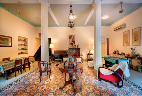 Ngôi nhà giữ nguyên phong cách Đông Dương xưa với cửa gỗ sơn xanh, sàn gạch vẽ tay, những cột chống nhà cũng như các bức tranh từ những năm 1940.
