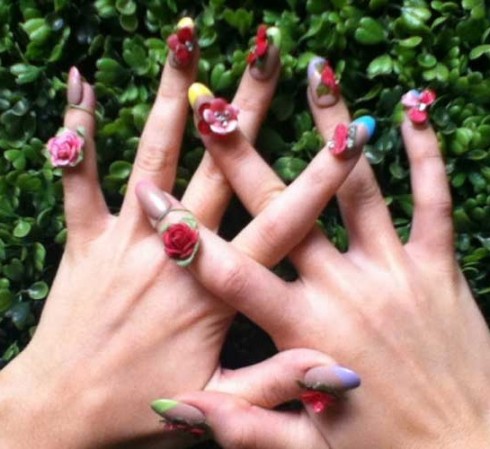 Thay vì vẽ hình trực tiếp lên móng, Katy Perry đã biến bàn tay của mình thành một "vườn hoa" nhỏ với những bông hồng làm từ đắt sét khô được đính trên bộ móng trong suốt với phần viền của những gam màu lạnh