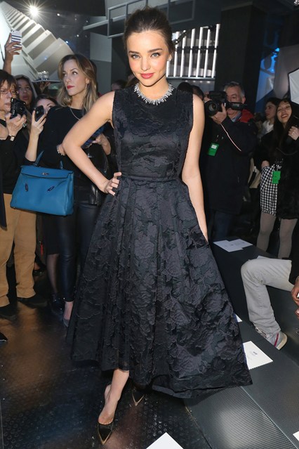 Miranda Kerr (mặc H&M) với đầm đen sang trọng nơi hàng ghế đầu của H&M.