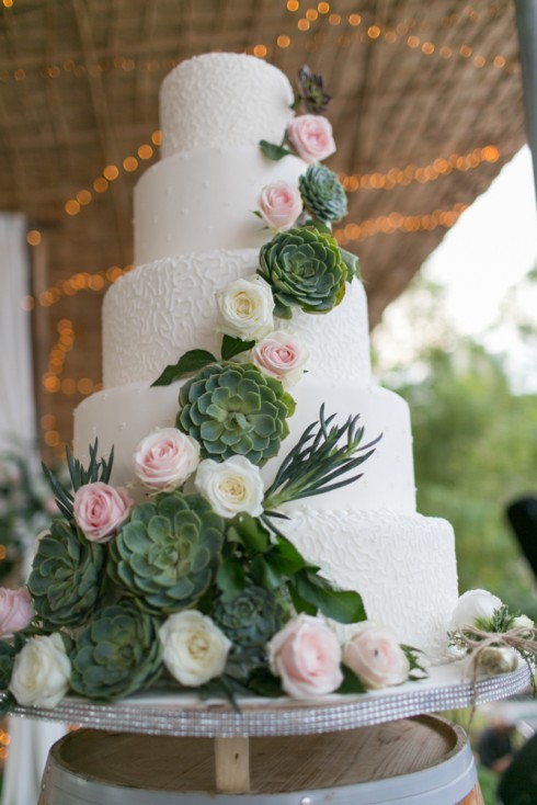Bánh cưới trắng tinh khiết trở nên nổi bật và ấn tượng với những bông hoa sứ xanh lạ mắt.
