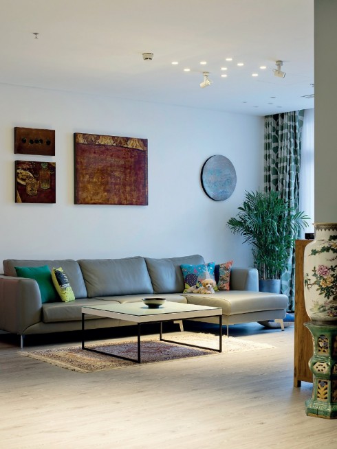Một góc phòng khách với sự cân đối trong bài trí giữa nhóm tranh sơn mài của họa sĩ Phi-Phi Oanh và họa sĩ Vũ Đức Trung với bộ sofa có thiết kế hiện đại của BoConcept.
