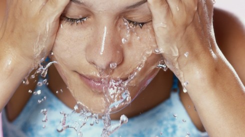 Young woman washing face, close-up