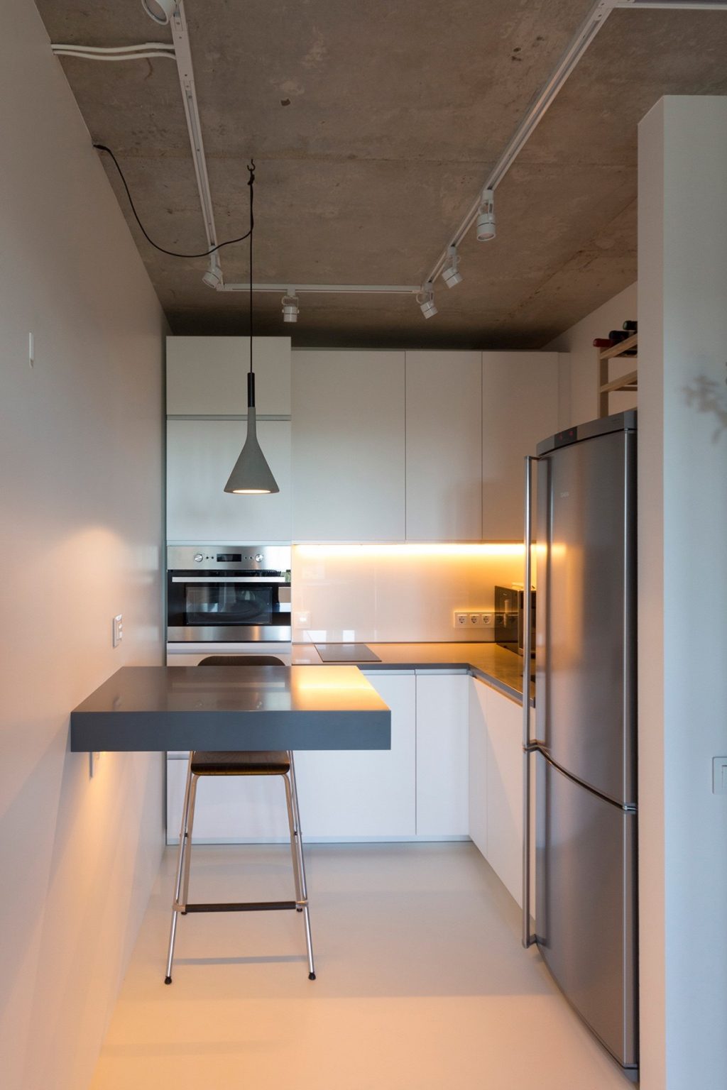 30.Minimalist-kitchen-white-walls-industrial-ceiling-grey-hanging-light-and-ledge-table
