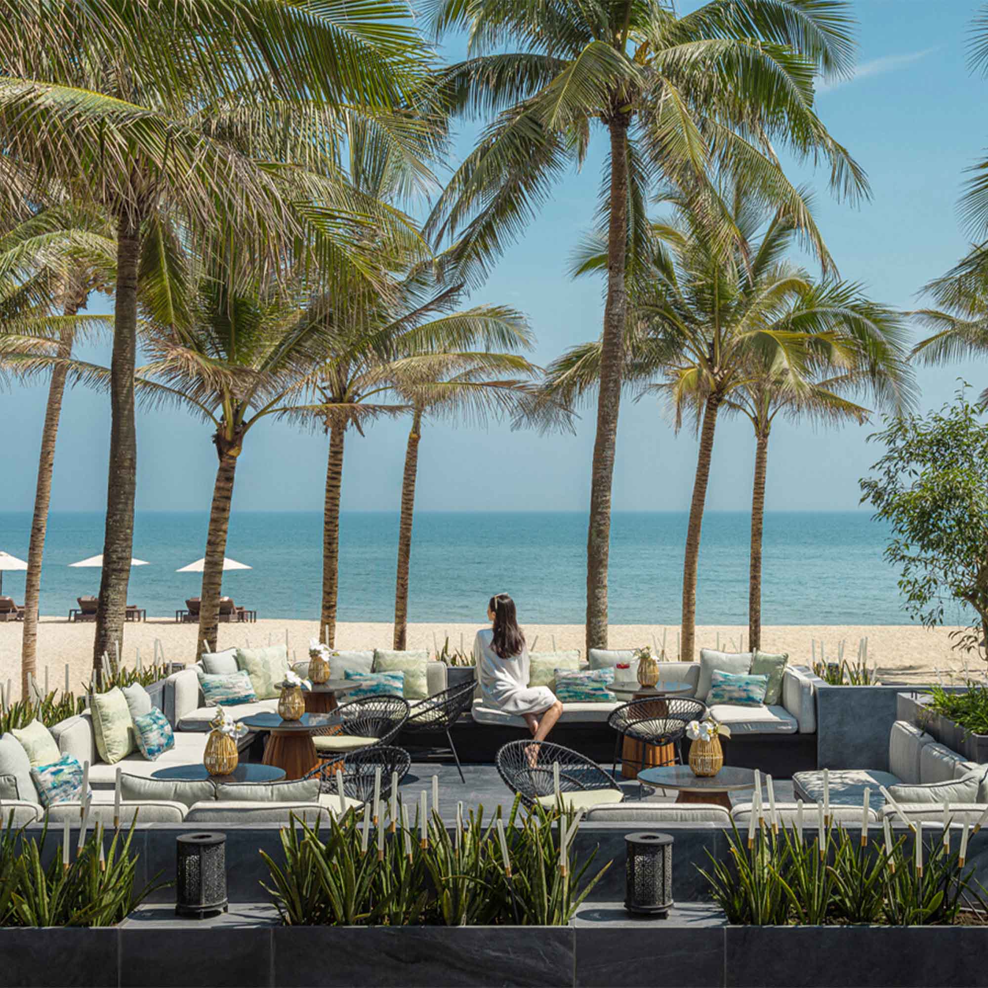 Cô gái đang ngồi ở khu vực ngoài trời tại Seasons Resort The Nam Hai