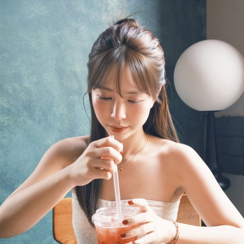Cô gái thưởng thức trà trong không gian cà phê thư giãn.