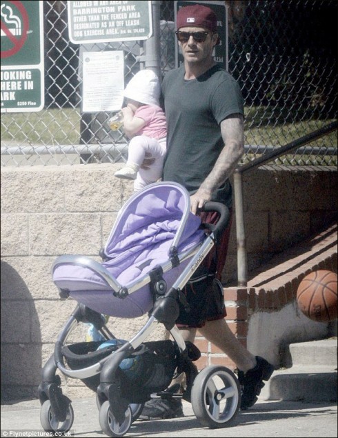 Tháng 8/2011, kiểu bế con rất ngầu của bố David Beckham. 