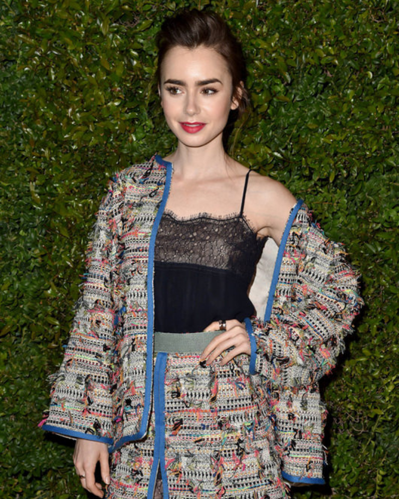 lily collins mặc áo ren hai dây phối với áo khoác và chân váy vải tweed