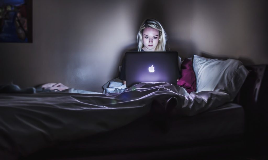 Phụ nữ làm việc với laptop trong bóng tối