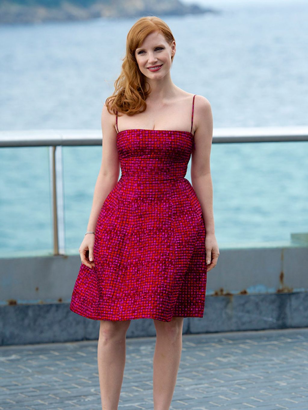 Jessica Chastain diện đầm hai dây màu đỏ và hồng và trang điểm với son môi đỏ tại liên hoan phim cannes