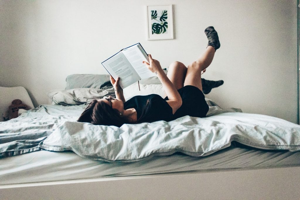 cô gái nằm đọc sách trên giường