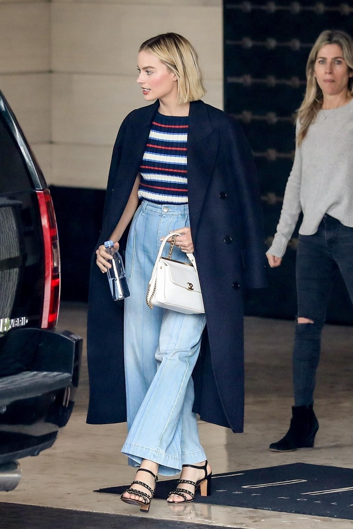 margot robbie mặc áo trench coat xanh navy áo kẻ sọc ngang quần jeans