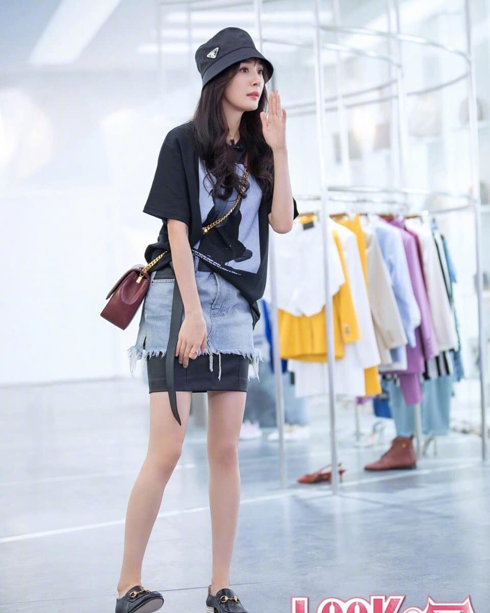 Dương Mịch mặc áo đen cùng chân váy denim và đội nón đen