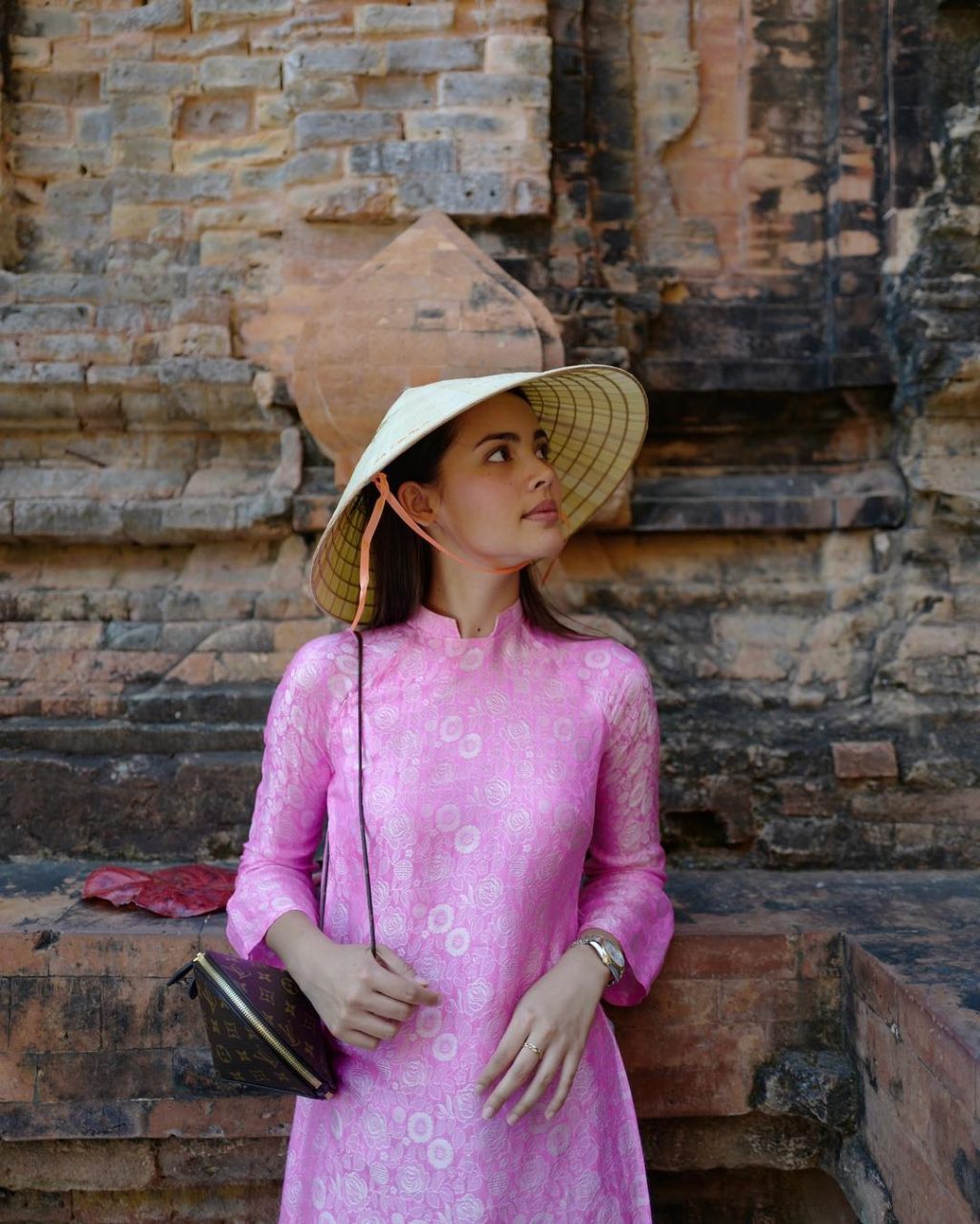 Diễn viên Urassaya Sperbund đội nón lá và diện áo dài Việt Nam màu hồng, cầm túi Louis Vuitton