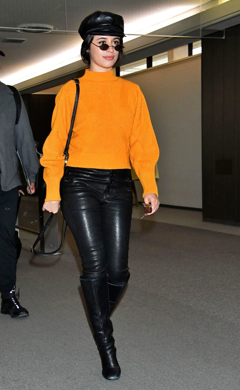 phong cách thời trang của Camilla Cabello diện quần da cùng boots cao cổ và sweater cam