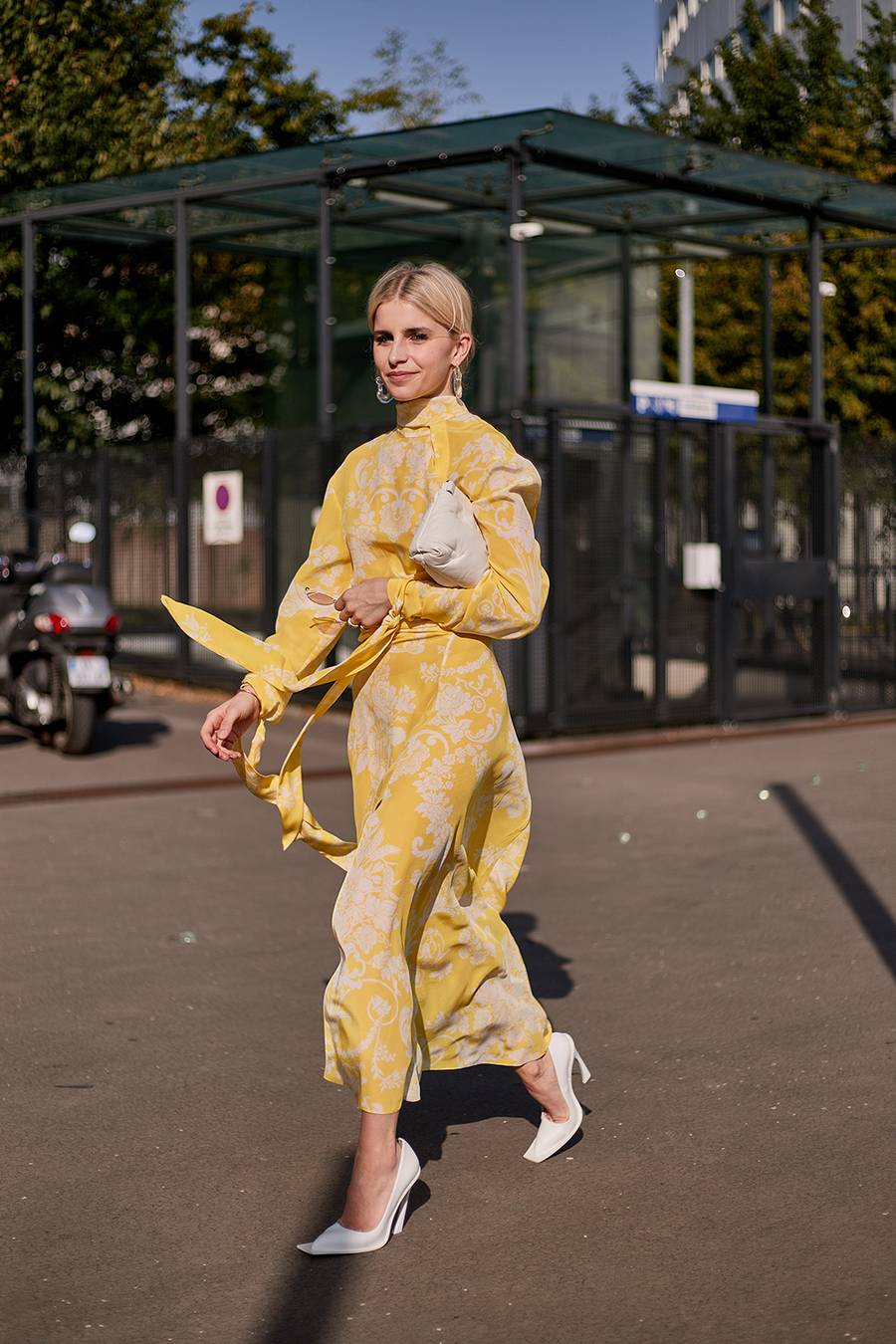Fashionista mặc váy vàng đi giày mũi vuông màu trắng
