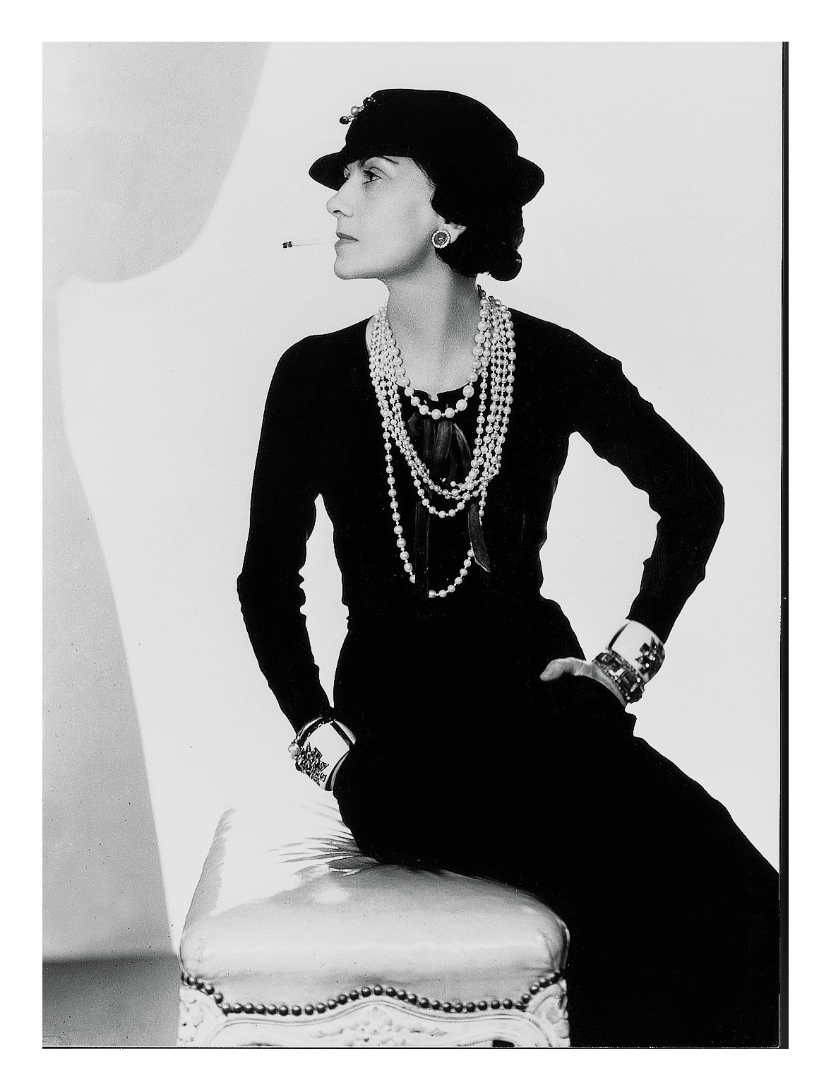 Coco Chanel mặc đầm đen, đeo dây chuyền ngọc trai