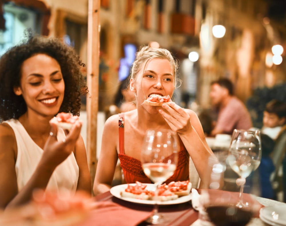 Thói quen ăn uống-Hai cô gái đang ăn pizza.