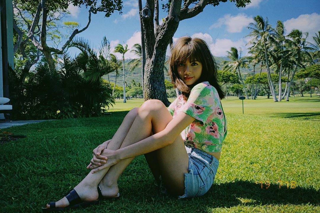 Lisa mặc áo in hoa và quần shorts jeans