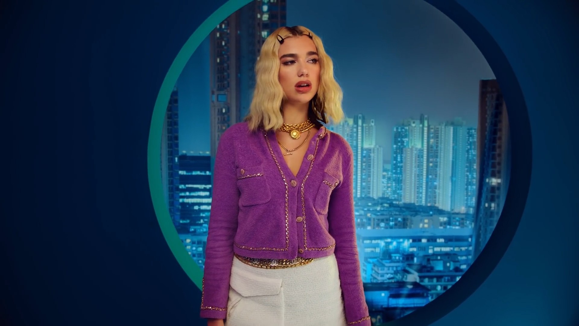 Dua Lipa mặc áo tím và chân váy ngắn, đeo vòng cổ xích vàng trong MV Break My Heart