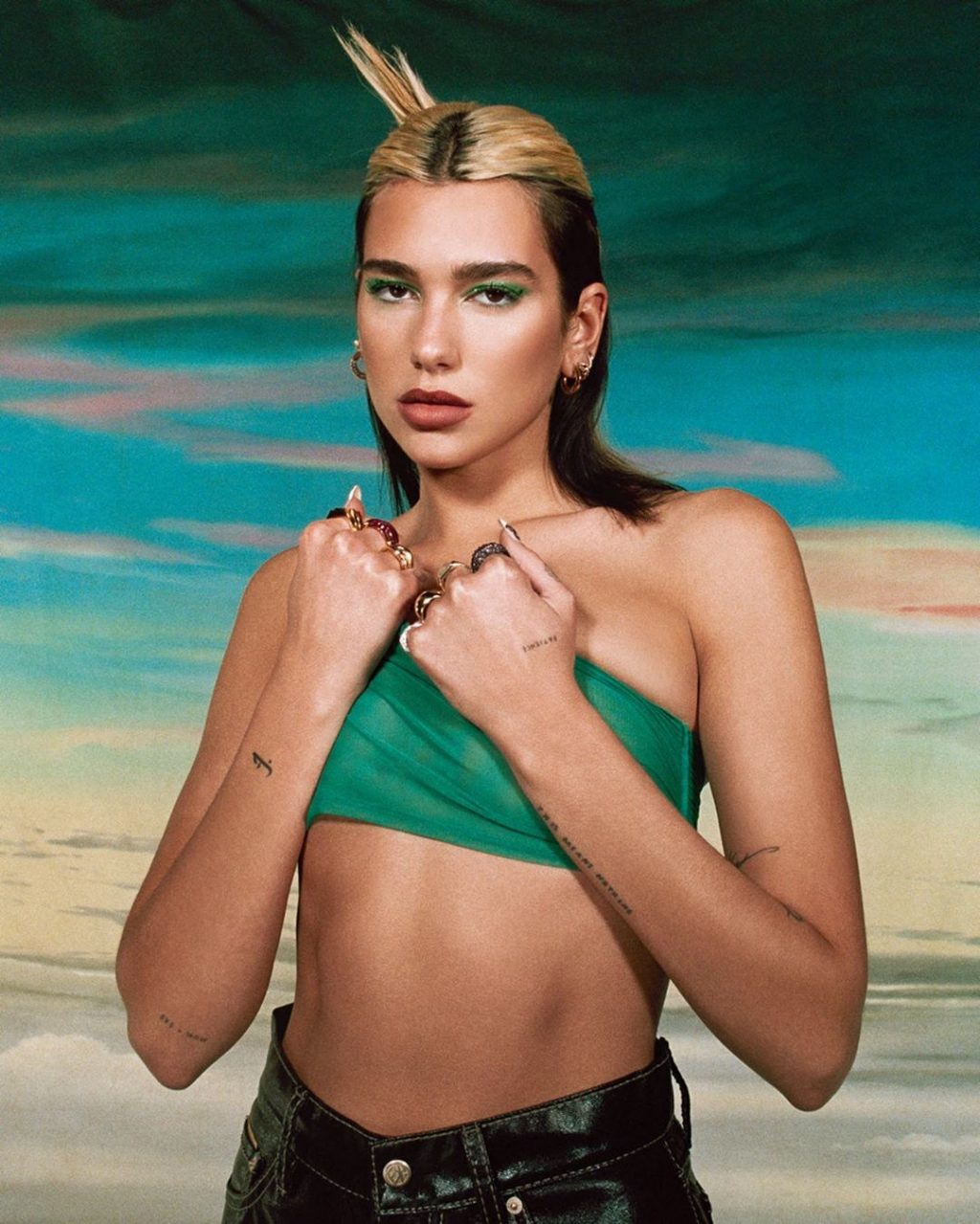 Dua Lipa mặc áo xanh lá.