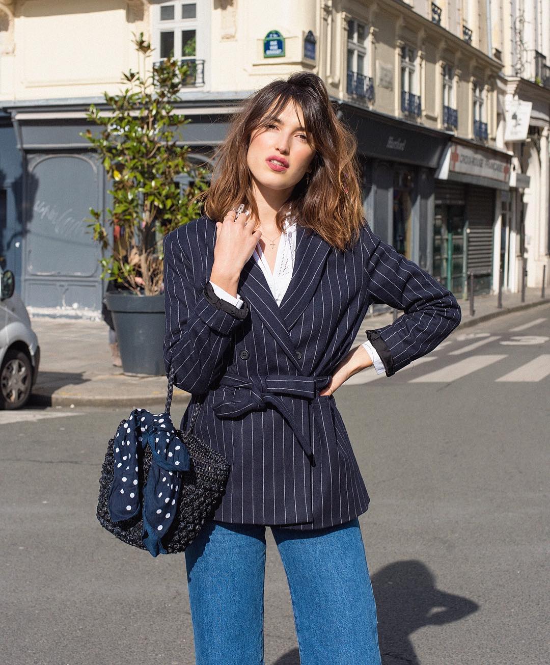 Thời trang Pháp của Jeanne Damas với áo blazer sọc, quần jeans, đeo túi cói đen